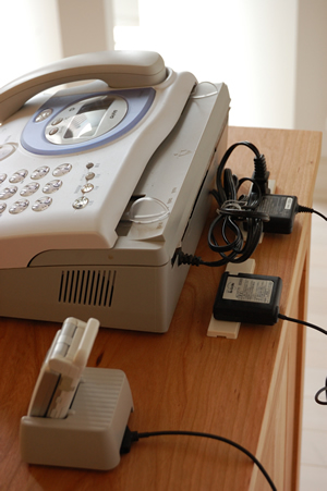 固定電話それもファックス機能付きの大きなタイプに加えてさらに家族の携帯電話が数台、ゴチャゴチャとして片付かなくて当然の近頃の電話まわり。